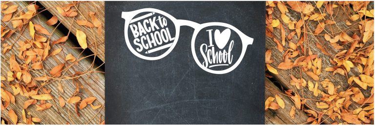 a wooden part covered with autumn leaves and a black slate with a glasses graphic and the words 'Back to school' and 'I heart school'.