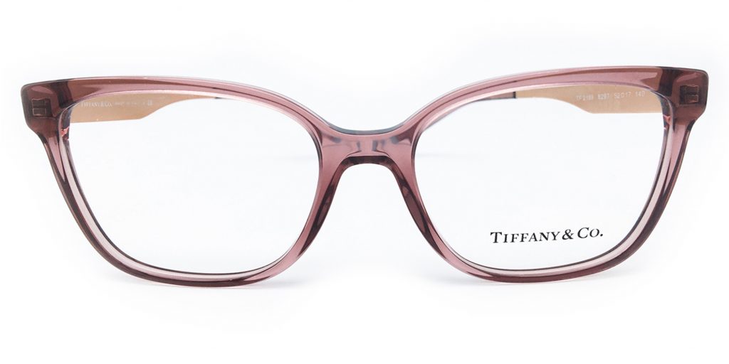 A pair of pale pink glasses frames with the Tiffany & Co logo on the lens.